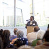 A woman speaks at the front of the room while at a podium.